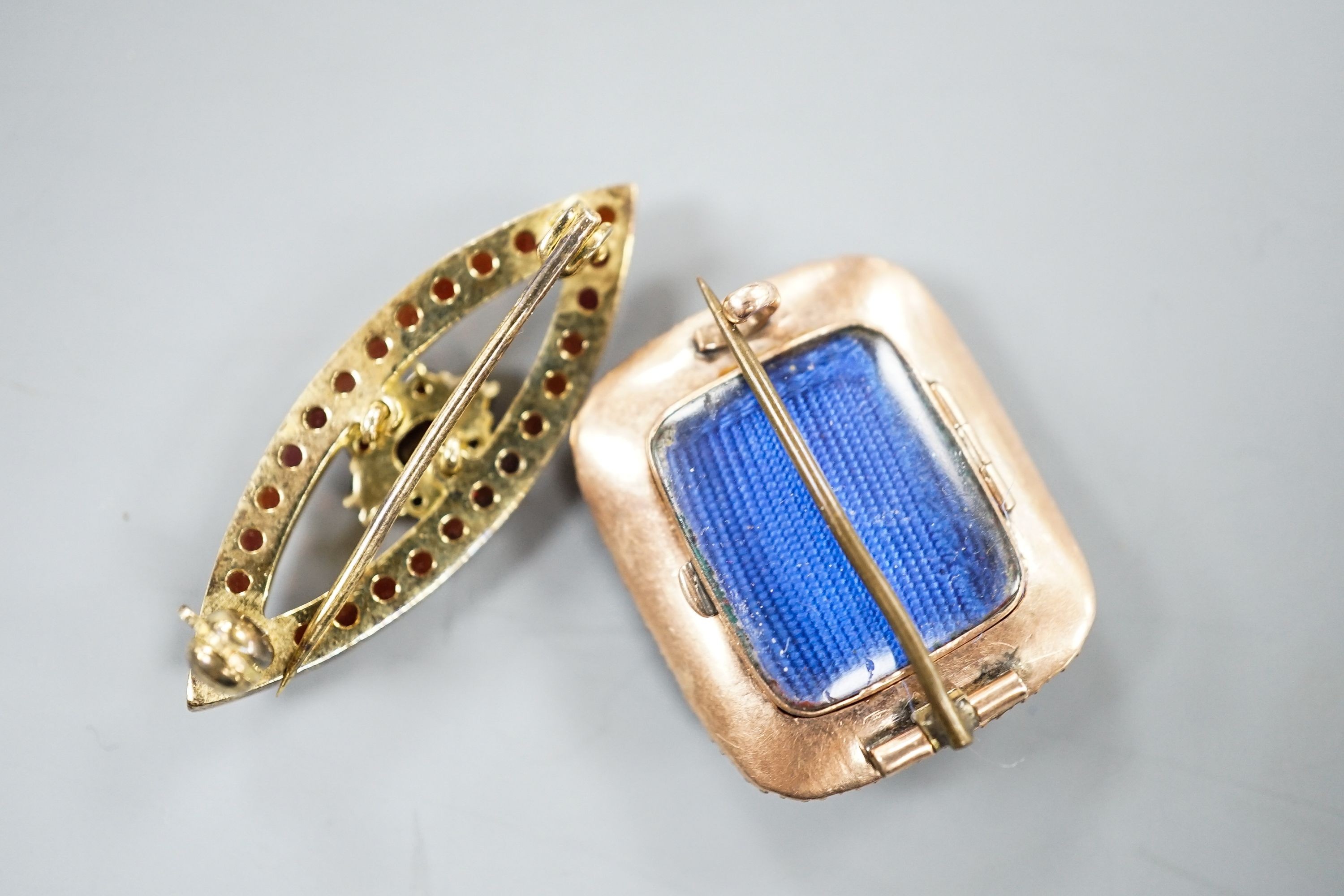 A Victorian yellow metal and spit pearl set mourning brooch, 23mm and 900 git white metal and garnet set brooch.